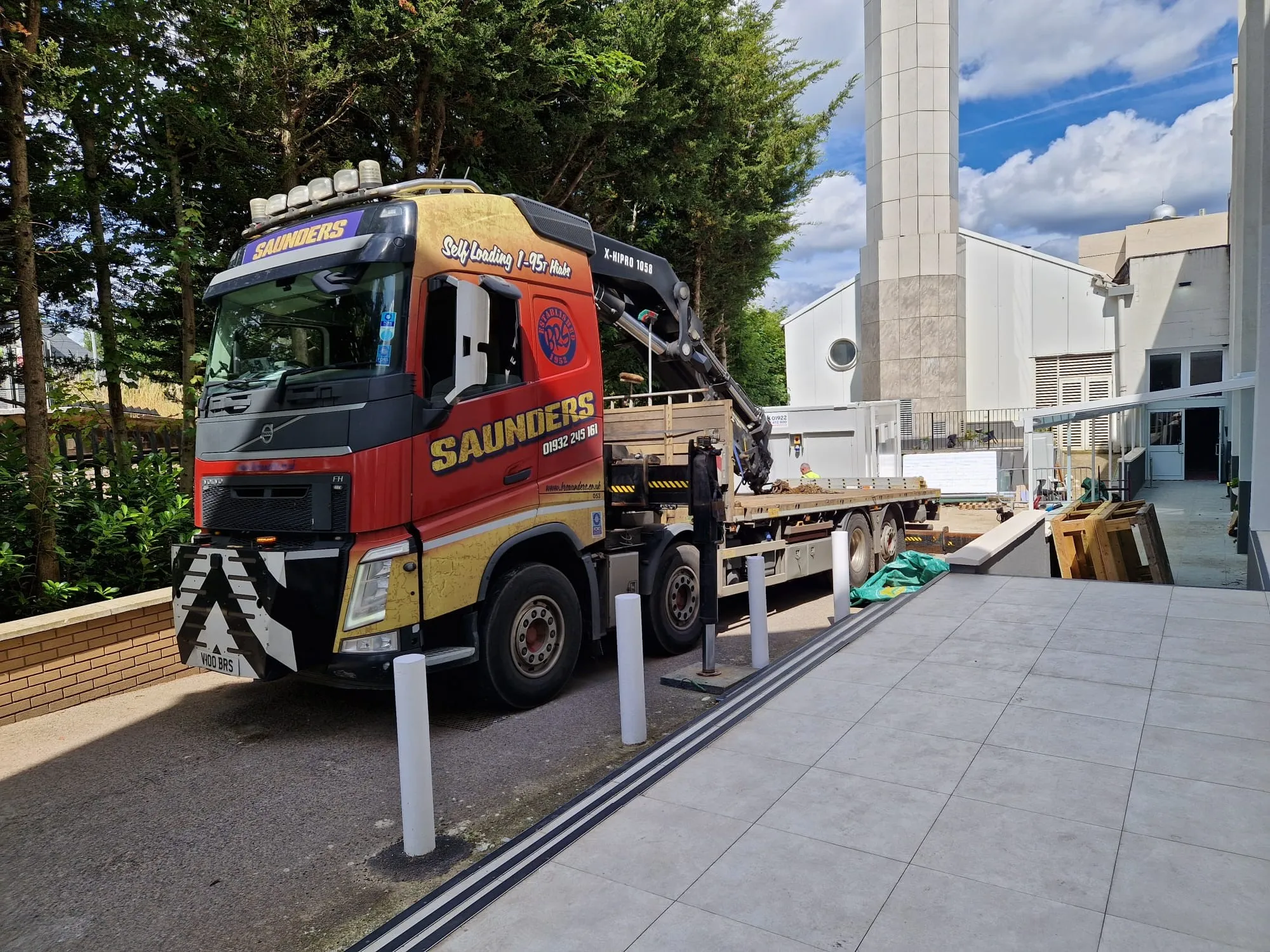 A red and yellow truck parked next to a building.